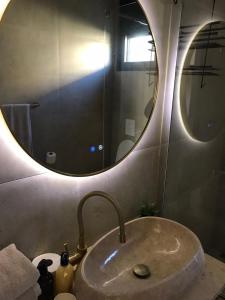 ein Badezimmerwaschbecken mit einem großen runden Spiegel darüber in der Unterkunft Holiday home Lemoni in Tivat