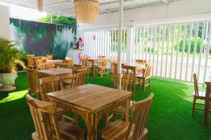a restaurant with wooden tables and chairs on green grass at ZABDI COVEÑAS in Coveñas