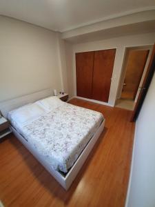 een slaapkamer met een bed en een houten vloer bij Departamento en Barrio La Perla, Mdp in Mar del Plata
