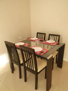 een eettafel met drie stoelen en een tafel met glazen bij Departamento en Barrio La Perla, Mdp in Mar del Plata