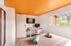 een slaapkamer met een bed en een bureau met een raam bij Studio Wellness & Détente Cosy in Maubec