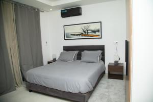 una camera da letto con un letto e una TV a parete di Appartement Neuf meublé de Haut Standing a Dakar