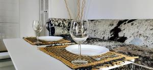 einen Tisch mit zwei Weingläsern und Tellern darauf in der Unterkunft La Nina A 5 min de Cassis in Roquefort-la-Bédoule