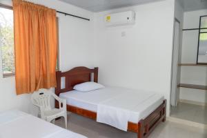 a bedroom with two beds and a chair and a window at ZABDI COVEÑAS in Coveñas +29 photos