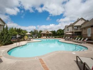 ein großer Pool in einem Resort mit Stühlen in der Unterkunft Landing Stunning 2BD Tennis Court Pool in McDonough