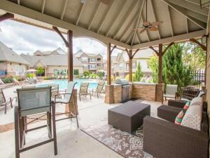 eine Außenterrasse mit einem Kamin und einem Pool in der Unterkunft Landing Stunning 2BD Tennis Court Pool in McDonough