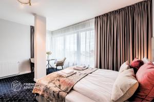 a bedroom with a large bed and a large window at SERENITY Aparthotels - Old Town Poznan by Friendly Apartments in Poznań