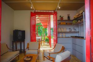 un soggiorno con divano, sedie e TV di Hacienda Santa Bárbara Coffee Farm a La Linda