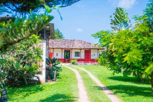 una casa con porte rosse e una strada sterrata di Hacienda Santa Bárbara Coffee Farm a La Linda