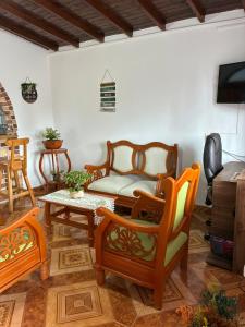 een woonkamer met houten stoelen en een bank bij Finca Vista Verde Guarne in Guarne