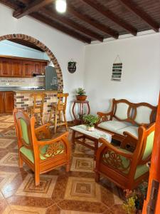 een woonkamer met stoelen en een tafel en een keuken bij Finca Vista Verde Guarne in Guarne