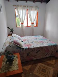 een slaapkamer met een bed en een raam bij Finca Vista Verde Guarne in Guarne