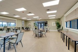 a dining room with tables and chairs and windows at River Strand Country Club Condo with Pool Access! in Bradenton