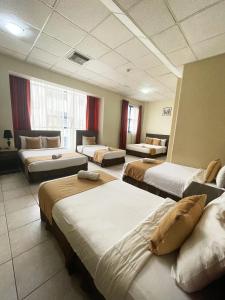 a hotel room with four beds and a couch at Hotel Las Peñas in Guayaquil