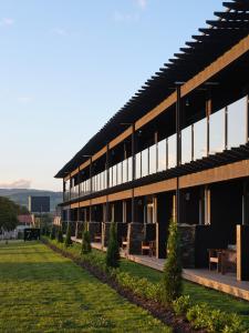 un grand bâtiment avec une pelouse devant dans l'établissement Suncourt Hotel & Conference Centre, à Taupo