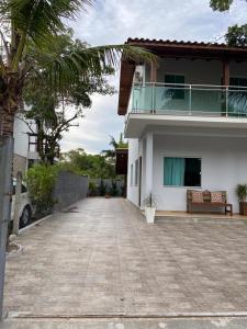 a large white house with a balcony and a driveway at Casa Ampla na Guarda do Embau in Lages