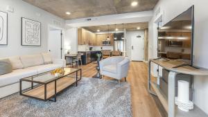 a living room with a couch and a table at Landing Modern Studio Rooftop Lounge Gym in Englewood