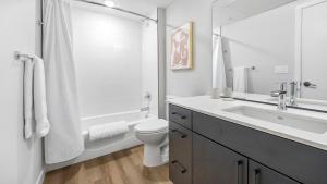 a bathroom with a sink and a toilet and a shower at Landing Modern Studio Rooftop Lounge Gym in Englewood +51 photos