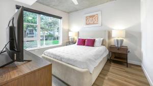 a bedroom with a bed and a flat screen tv at Landing Modern Studio Rooftop Lounge Gym in Englewood
