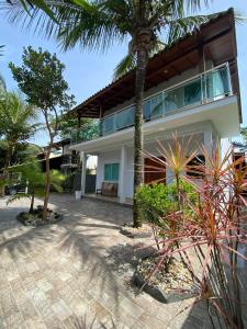 a house with a palm tree in front of it at Casa Ampla na Guarda do Embau in Lages