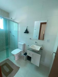a bathroom with a toilet and a sink and a mirror at Casa Ampla na Guarda do Embau in Lages +70 photos