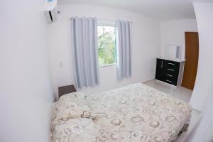 a bedroom with a bed and a window at Casa Ampla na Guarda do Embau in Lages