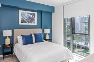 een slaapkamer met blauwe muren en een bed met blauwe kussens bij Landing Stunning 3BD Pool Gym in Naranja +32 foto's