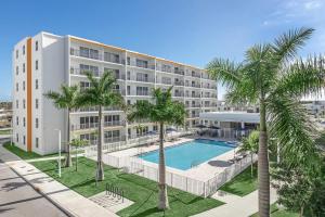 een appartementencomplex met een zwembad en palmbomen bij Landing Stunning 3BD Pool Gym in Naranja