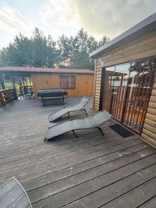 a deck with two benches and a picnic table at Pasakų namelis in Svėdasai