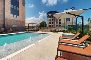a swimming pool with two chairs and an umbrella at Landing Stunning 2BD in Corinth in Denton