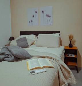 une chambre avec un lit avec un livre et une télécommande dans l'établissement Wind Village Icaraizinho, à Icaraí