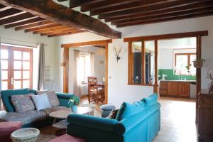 een woonkamer met een blauwe bank en een tafel bij Gîtes Le Gros Chêne in Meaucé