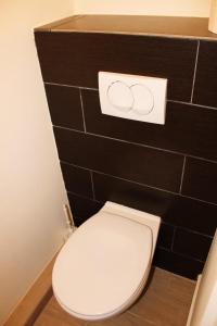 a white toilet in a bathroom with a black wall at City Centre Apartment in Budapest