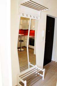 a mirror in a room with a bench and a kitchen at City Centre Apartment in Budapest +8 photos