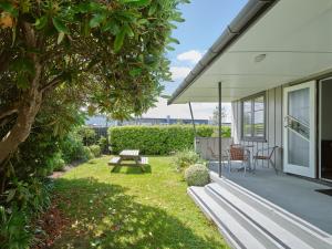 une cour arrière avec une table de pique-nique et un banc dans l'établissement Suncourt Hotel & Conference Centre, à Taupo