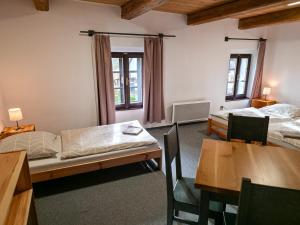a room with two beds and a table and chairs at Pivovar Mlýn in Štětí