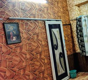 a wall with a picture and a mirror on it at Siddhi's Inn in Prayagraj