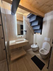 a bathroom with a toilet and a sink and a mirror at Muranche Loft S1 in Valtournenche