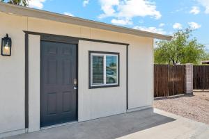 een garage met een blauwe deur en een hek bij Cozy Studio Retreat with Private Bath & Kitchenette in Tempe