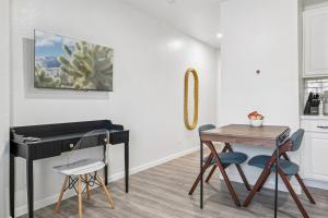 een kamer met een bureau en een tafel en stoelen bij Cozy Studio Retreat with Private Bath & Kitchenette in Tempe