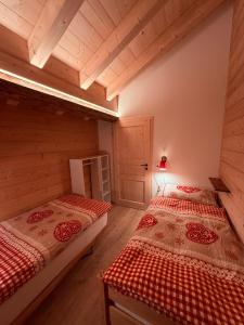 deux lits dans une chambre avec parquet et plafonds en bois dans l'établissement Staubbachbänkli, à Wengen