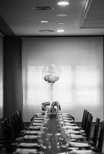 Ein langer Tisch mit Weingläsern vor einer Wand in der Unterkunft Hotel Villa de Andosilla in Andosilla