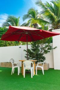 a table and two chairs and a red umbrella at ZABDI COVEÑAS in Coveñas