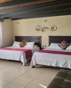ein Schlafzimmer mit zwei Betten in einem Zimmer in der Unterkunft Hotel Villalba in Comitán de Domínguez