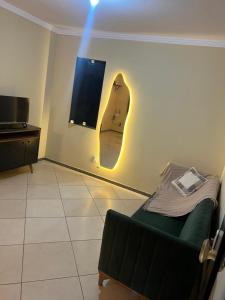 een kamer met een bank en een surfplank aan de muur bij Beira Mar in Aracaju