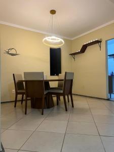 een eetkamer met een tafel, stoelen en een televisie bij Beira Mar in Aracaju