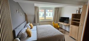 a bedroom with a bed and a desk and a television at Gasthaus Harmonie in Malchow