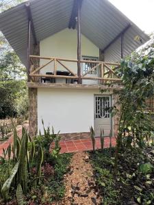 a house with a balcony on top of it at Finca Hotel Yamboró in Pitalito