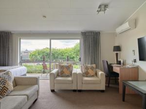 Cette chambre comprend un lit, des chaises et un bureau. dans l'établissement Suncourt Hotel & Conference Centre, à Taupo