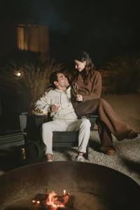 a man and a woman sitting next to a fire at Equ Hotel Boutique in El Porvenir